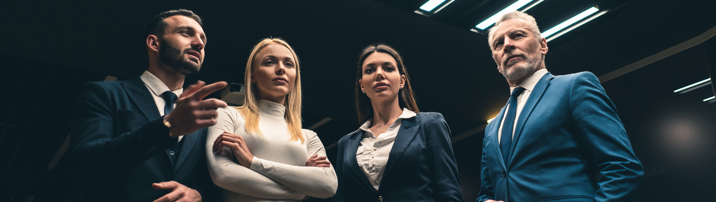 The four business people standing in the night offi ... The four business people standing in the night office